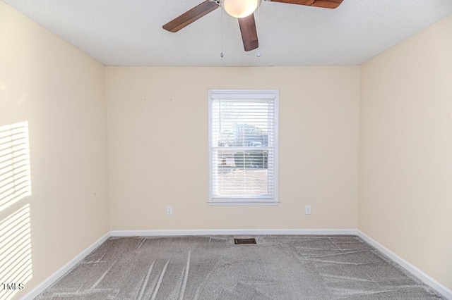 unfurnished room with visible vents, baseboards, a ceiling fan, and carpet flooring