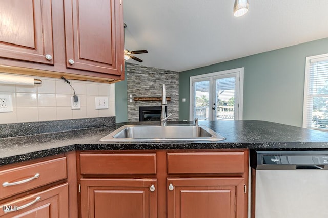 kitchen with plenty of natural light, dishwasher, a fireplace, and decorative backsplash