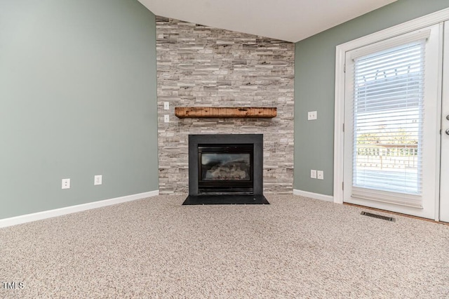 unfurnished living room with visible vents, baseboards, lofted ceiling, carpet flooring, and a fireplace