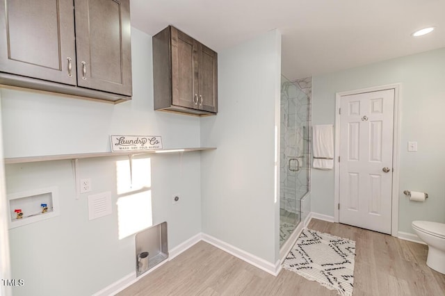 washroom with washer hookup, light wood-style flooring, cabinet space, baseboards, and hookup for an electric dryer