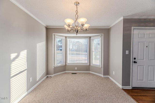 unfurnished dining area featuring crown molding, a notable chandelier, baseboards, and a textured ceiling