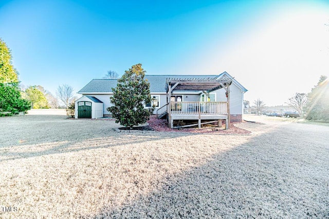 ranch-style home featuring a wooden deck, an outbuilding, a shed, and a pergola