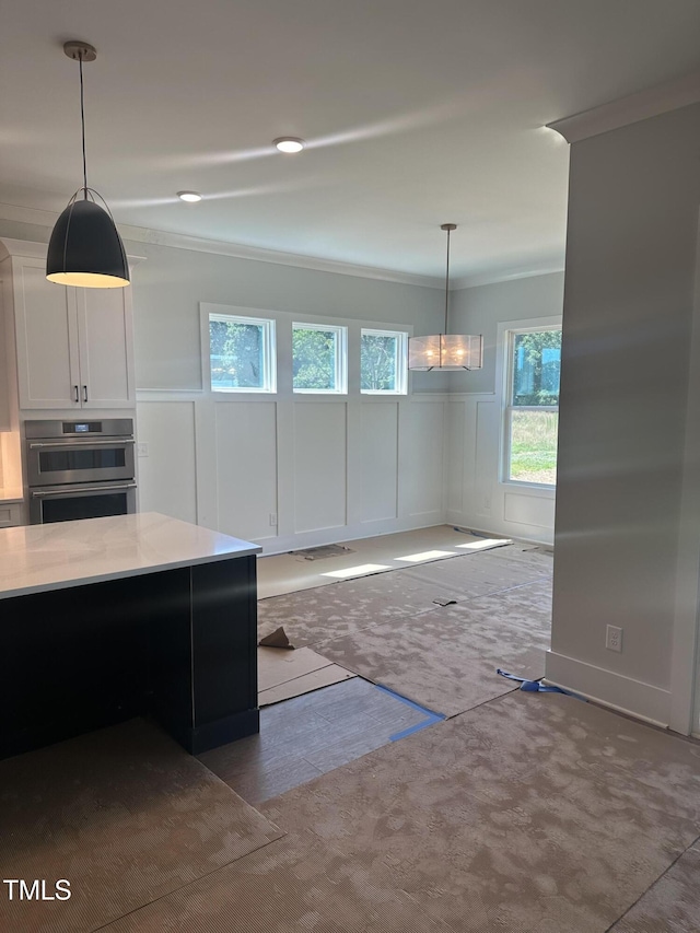 9000 Penny Rd, Raleigh, NC 27606 - kitchen with crown molding, pendant lighting, a chandelier, white cabinets, and a decorative wall