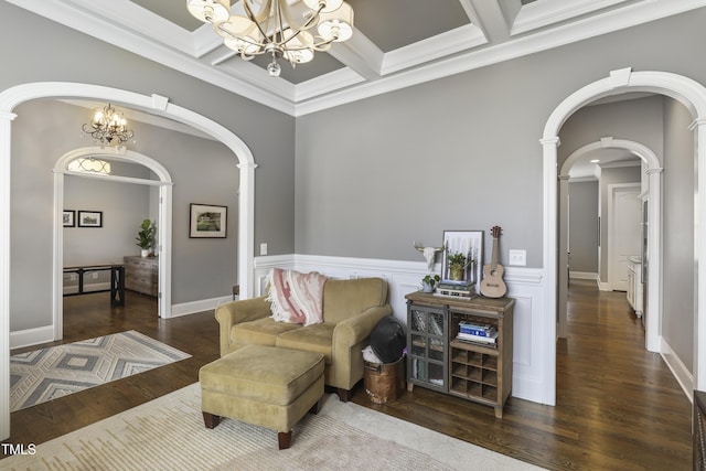 living area featuring a notable chandelier, wood finished floors, arched walkways, and coffered ceiling