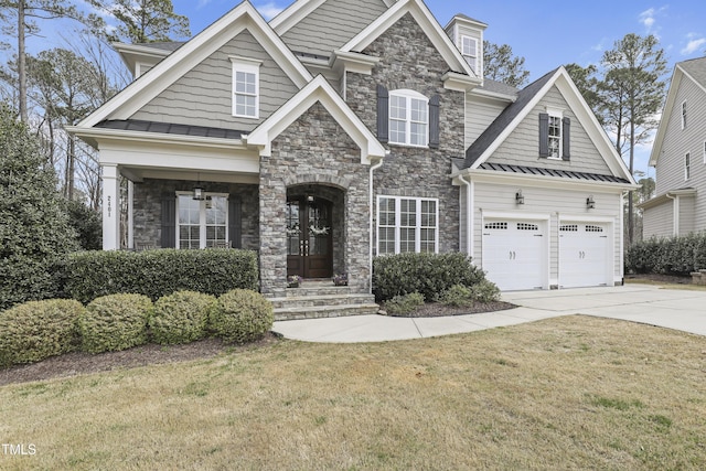 craftsman house with stone siding, a front lawn, driveway, and a shingled roof