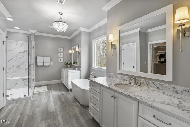 bathroom with ornamental molding, baseboards, a marble finish shower, and a sink