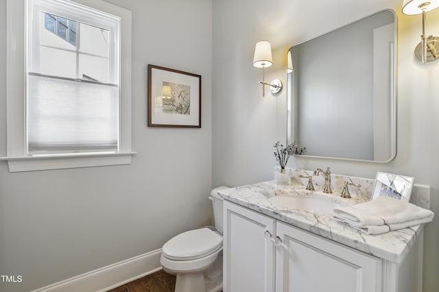 bathroom with baseboards, toilet, and vanity