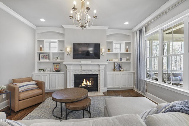 living area featuring a fireplace with flush hearth, ornamental molding, an inviting chandelier, baseboards, and dark wood-style flooring