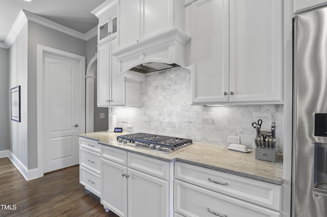 kitchen with tasteful backsplash, ornamental molding, light stone counters, stainless steel appliances, and white cabinetry