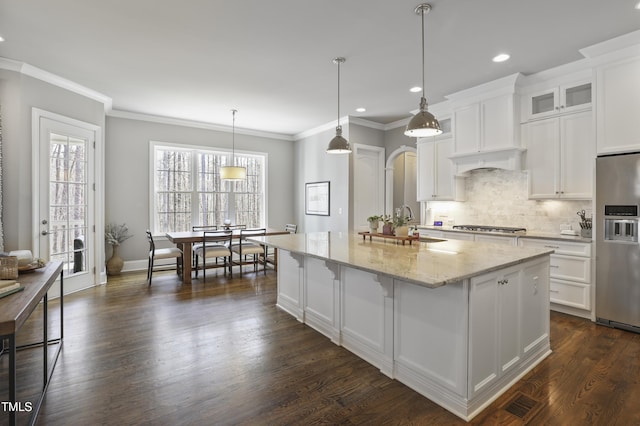 kitchen with light stone countertops, dark wood-style flooring, stainless steel appliances, decorative backsplash, and white cabinets