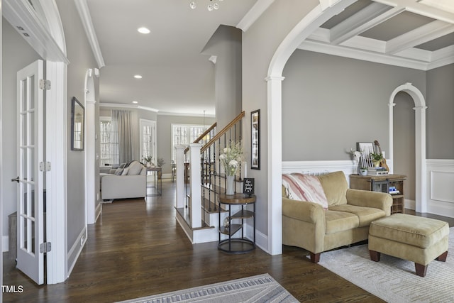 entryway featuring stairs, crown molding, decorative columns, and wood finished floors