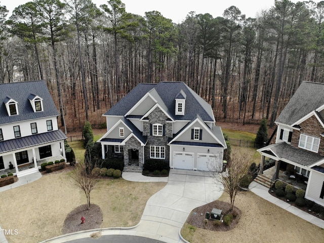 view of front of house with stone siding, covered porch, driveway, and a garage