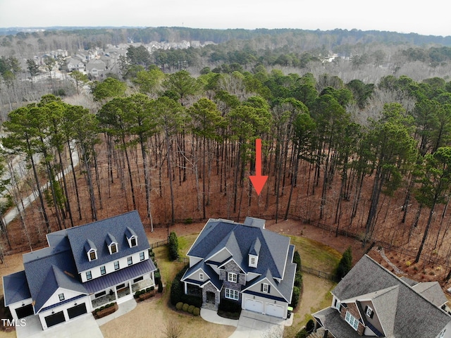 bird's eye view with a wooded view