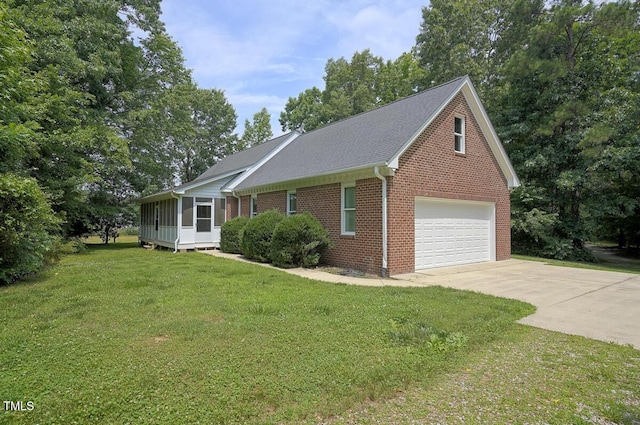 view of front facade with a front lawn, a sunroom, brick siding, and driveway