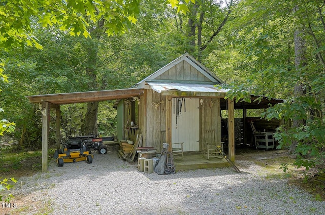 view of outbuilding featuring an outdoor structure and a view of trees