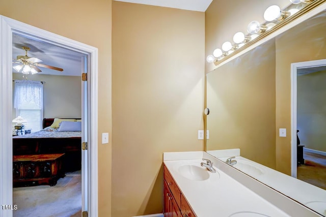 bathroom featuring double vanity, ensuite bath, a ceiling fan, and a sink