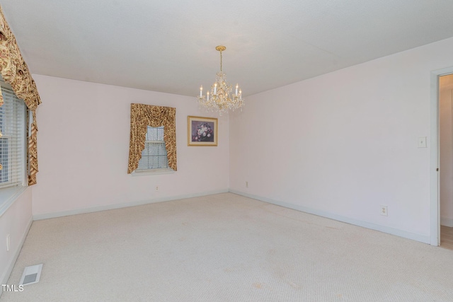 unfurnished room featuring an inviting chandelier, light colored carpet, visible vents, and baseboards