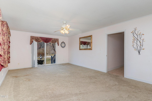 carpeted empty room featuring baseboards and a ceiling fan