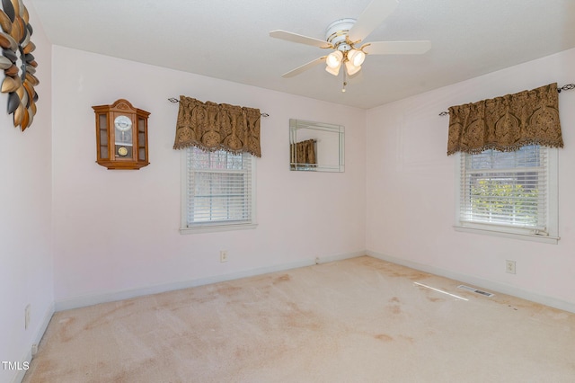 unfurnished room with carpet flooring, baseboards, visible vents, and ceiling fan