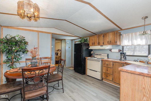 kitchen featuring electric range, under cabinet range hood, a sink, freestanding refrigerator, and vaulted ceiling