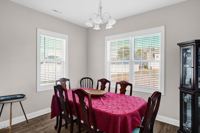 dining space with a notable chandelier, visible vents, baseboards, and dark wood-style flooring