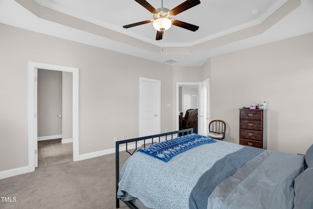 bedroom with visible vents, crown molding, baseboards, a tray ceiling, and carpet flooring