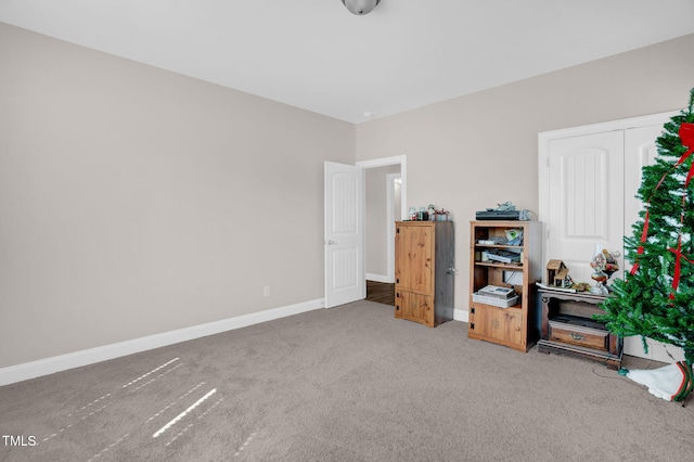 interior space with baseboards and carpet