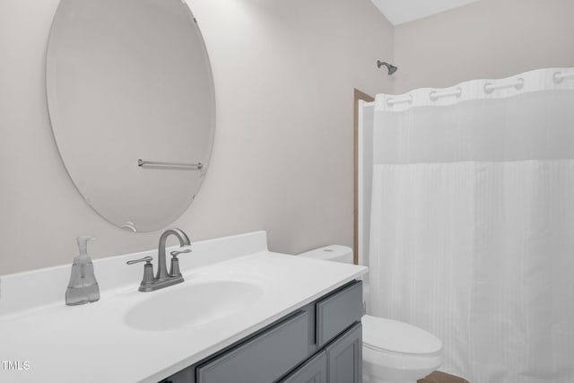 bathroom featuring a shower with shower curtain, toilet, and vanity