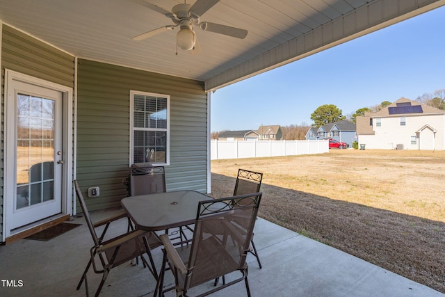 view of patio / terrace featuring a residential view, outdoor dining area, ceiling fan, and fence