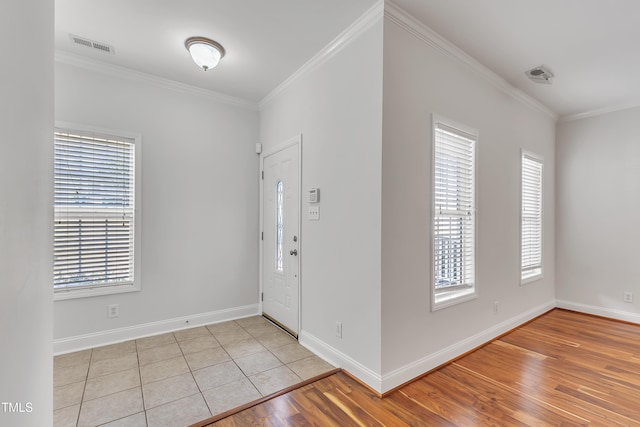 entrance foyer featuring light wood finished floors, visible vents, crown molding, and baseboards