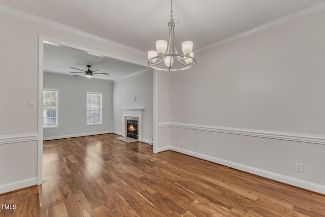 unfurnished living room featuring a fireplace with flush hearth, crown molding, baseboards, and wood finished floors