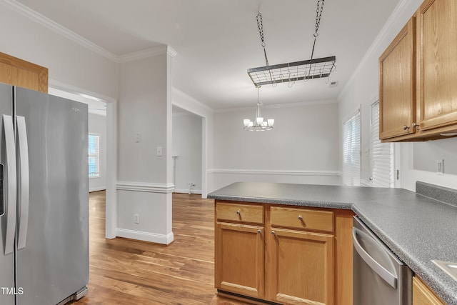 kitchen featuring dark countertops, ornamental molding, light wood-style flooring, a peninsula, and stainless steel appliances