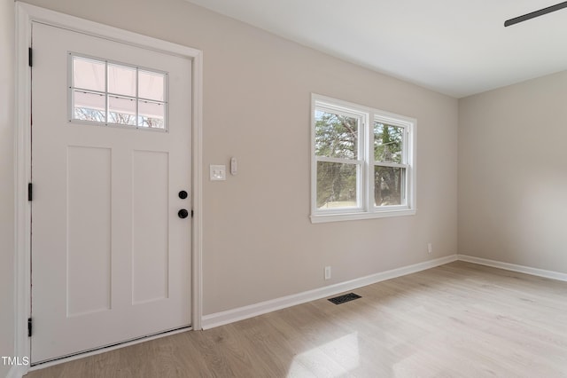 entryway with visible vents, light wood-style floors, baseboards, and ceiling fan