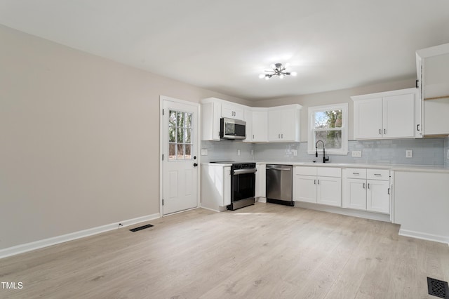 kitchen with visible vents, plenty of natural light, stainless steel appliances, and a sink