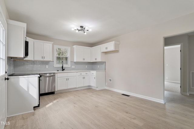 kitchen with visible vents, a sink, decorative backsplash, light wood-style floors, and dishwasher