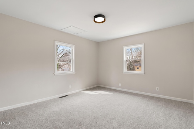 unfurnished room with plenty of natural light, carpet, visible vents, and baseboards