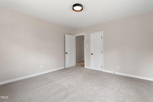 carpeted spare room featuring baseboards