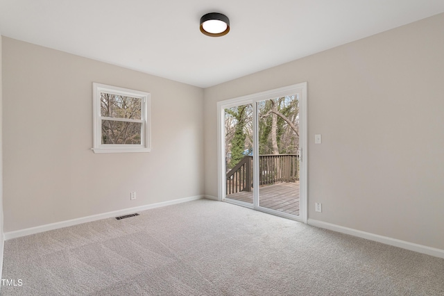 carpeted spare room with visible vents and baseboards