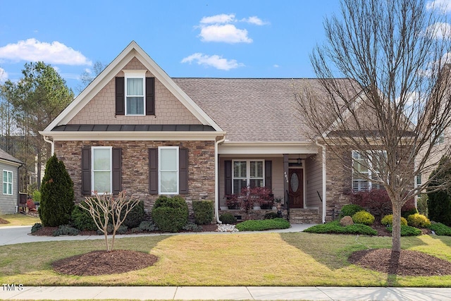 craftsman inspired home featuring stone siding, a shingled roof, and a front lawn