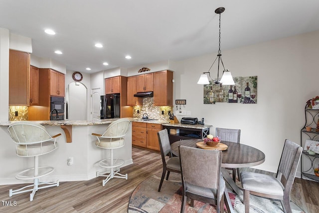 dining space with recessed lighting, baseboards, and light wood finished floors