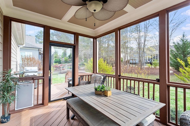 sunroom / solarium featuring a healthy amount of sunlight and a ceiling fan