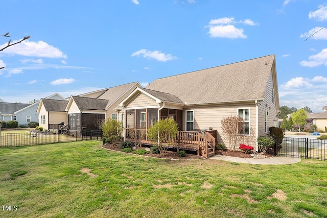 rear view of property with a lawn, a fenced backyard, and a sunroom