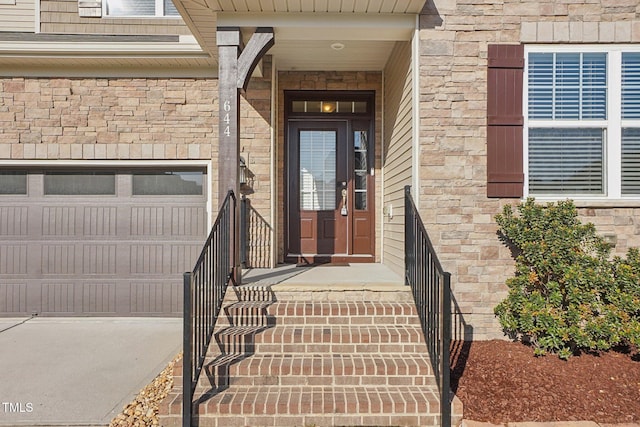 doorway to property with a garage and stone siding