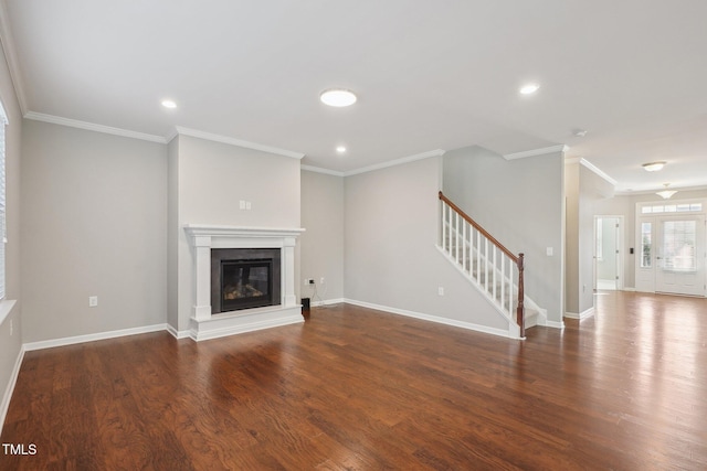 unfurnished living room featuring a glass covered fireplace, stairway, wood finished floors, and ornamental molding