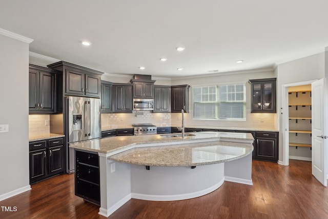 kitchen featuring a sink, dark wood finished floors, an island with sink, appliances with stainless steel finishes, and open shelves