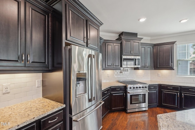 kitchen featuring light stone counters, dark wood-style floors, appliances with stainless steel finishes, crown molding, and tasteful backsplash