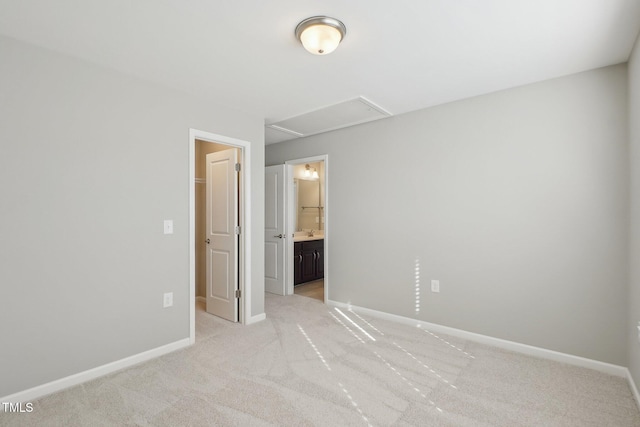 unfurnished bedroom featuring a sink, connected bathroom, baseboards, and light colored carpet