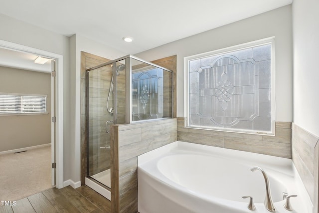 full bath with baseboards, a garden tub, and a stall shower