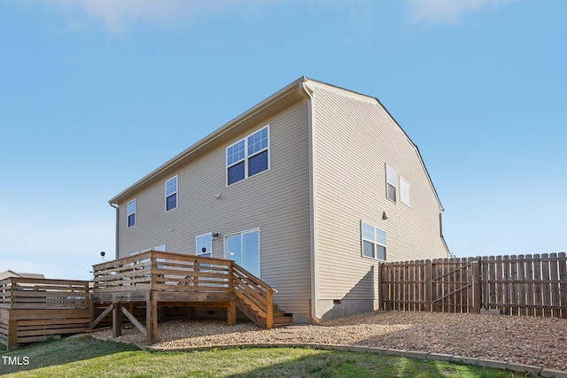 rear view of property featuring a deck, fence, and crawl space