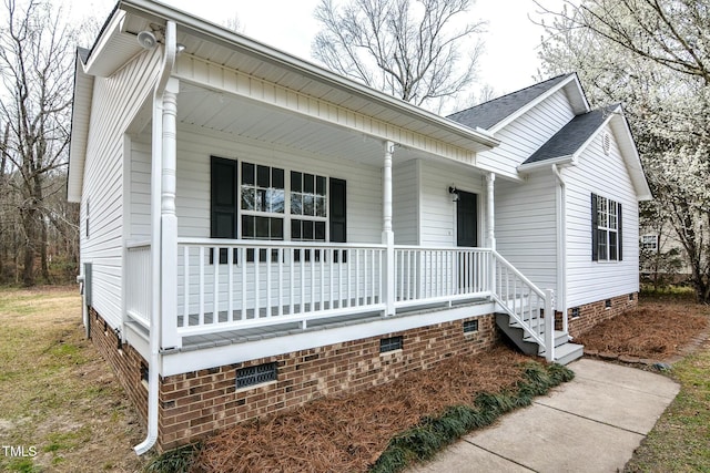 view of front of house with crawl space, a porch, and a shingled roof